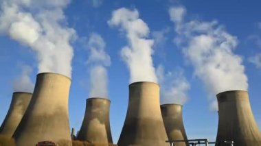 Time lapse footage of steam rising from cooling towers