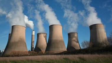 Steam and smoke rising from power station cooling towers