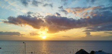 Güneş Hunstanton, Norfolk, İngiltere 'de sakin bir denizin üzerinde batıyor.