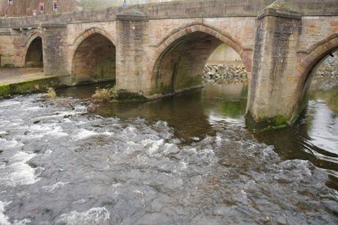 Derwent Nehri, Matlock, Derbyshire, İngiltere 'deki kemerli bir taş yol köprüsünün altından akıyor.