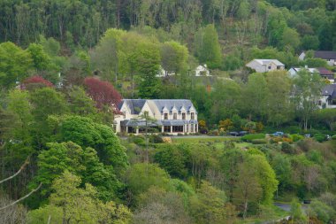 İskoçya 'nın Skye Adası, Portree' de ağaçlık bir yamaçta büyük bir ev.
