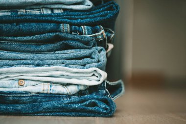 Katlanmış kot pantolon yığını. Moda, tarz, stok ve mağaza konsepti. Yüksek kalite fotoğraf