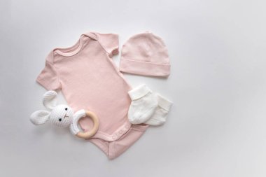 Bebek kıyafetleri, aksesuarlar ve gri arka planda oyuncaklar. Yeni doğmuş vücut, şapka ve çoraplar. Yeni doğan temel ihtiyaçlar ve annelik kavramı. Yüksek kalite fotoğraf