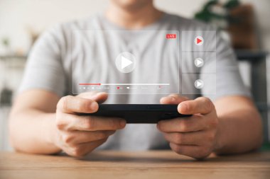 Bilgisayarlı çevrimiçi film, cep telefonunda hayali video oynatıcı servisi olan bir film izleyen genç adam..