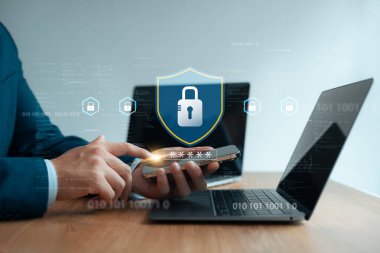 Siber güvenlik, şifreli dizüstü bilgisayar ve akıllı telefon kullanan işadamı kişisel bilgileri çevrimiçi olarak korumak, gizli verileri korumak, hacker saldırılarının önlenmesi.