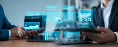 Fütürist dijital arayüzler kullanarak veri analizi yapan ve el sıkışan iki profesyonelin iş ortaklığı kavramı, işbirliği, güven ve yeniliği temsil etmektedir..