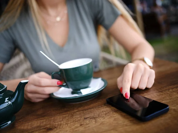 Uma Mulher Senta Cafetaria Desfrutando Chá Usa Seu Telefone Para — Fotografia de Stock