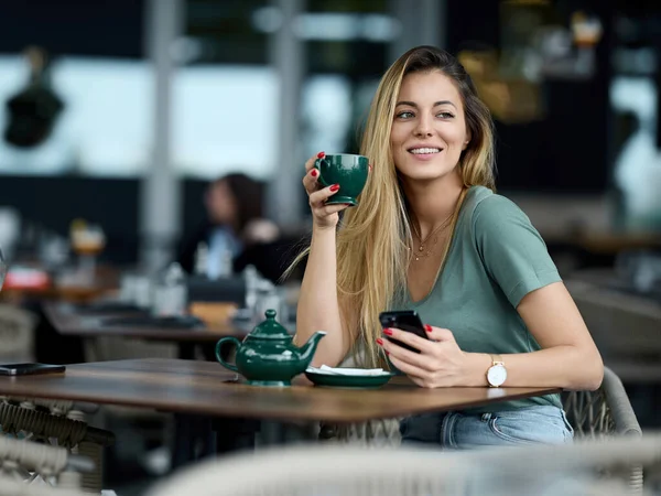 Женщина Сидит Кафетерии Наслаждается Чаем Использует Свой Телефон Онлайн Чата — стоковое фото