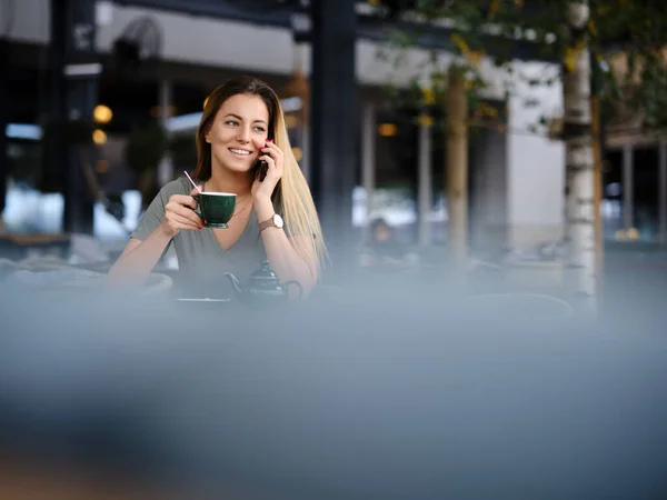 Uma Mulher Senta Cafetaria Desfrutando Chá Usa Seu Telefone — Fotografia de Stock