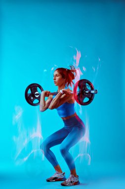 Halter kaldıran bir kadın vücutçunun stüdyo fotoğrafı..