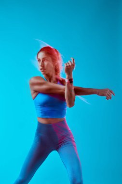 Stüdyoda egzersiz yapan kaslı bir sporcu kadın. Uzun pozlama yakalama hareketi.