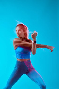 Stüdyoda egzersiz yapan kaslı bir sporcu kadın. Uzun pozlama yakalama hareketi.