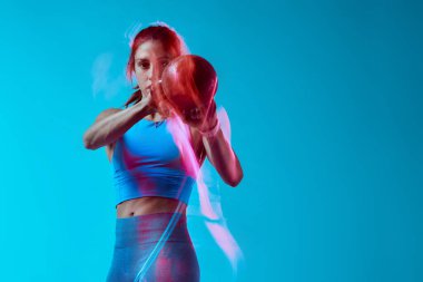 Stüdyoda kettlebell kaldıran bir bayan vücut geliştirici. Uzun pozlama hareketi yakalaması.