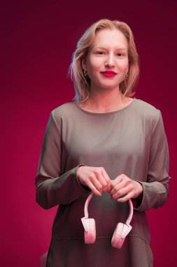 Portrait of a serious young blond woman isolated on magenta background. Viva magenta.
