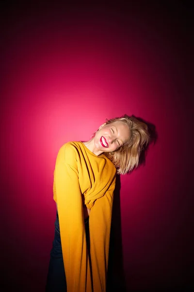 Happy Young Blond Woman Laughing While Standing Front Magenta Background — Fotografia de Stock