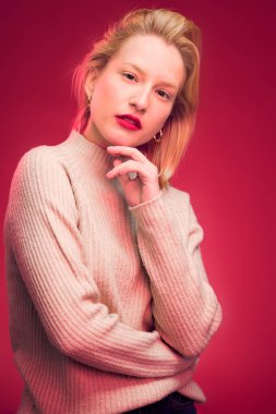 Portrait of a serious woman posing in studio isolated on magenta background. Viva magenta.