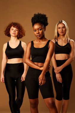 Three multiracial girls in underwear with pure natural skin with no makeup posing in studio.