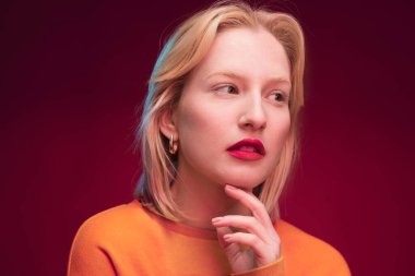 Portrait of a beautiful lady isolated on magenta background looking away. Viva magenta, color of the year.