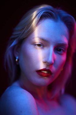 Beauty portrait of a serious blond woman with natural pure skin. Picture taken with photo gels.