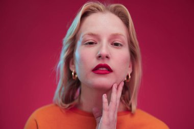 Portrait of a happy woman listening to music isolated on red background.