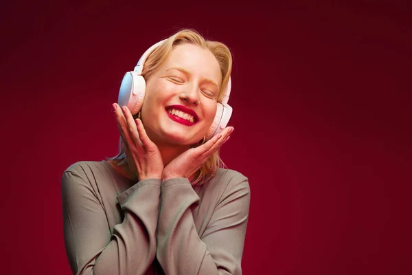 Μια Χαρούμενη Νεαρή Γυναίκα Που Ακούει Μουσική Ακουστικά Και Χαμογελά — Φωτογραφία Αρχείου