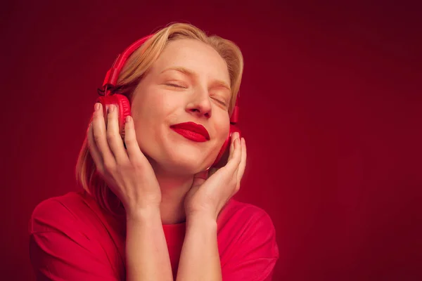Een Gelukkige Vrouw Ontspannen Luisteren Muziek Geïsoleerd Rode Achtergrond — Stockfoto