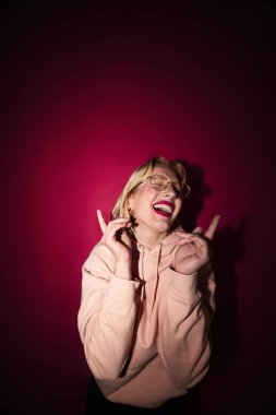 Portrait of a happy girl laughing and posing isolated on magenta background. Viva magenta, color of the year.