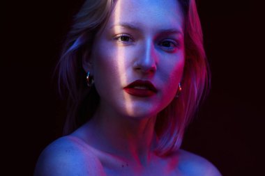 Beauty portrait of a woman with natural skin posing isolated on magenta background with photo gels. Viva magenta, color of the year.