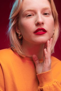 Portrait of a beautiful lady isolated on magenta background looking at the camera. Viva magenta, color of the year.