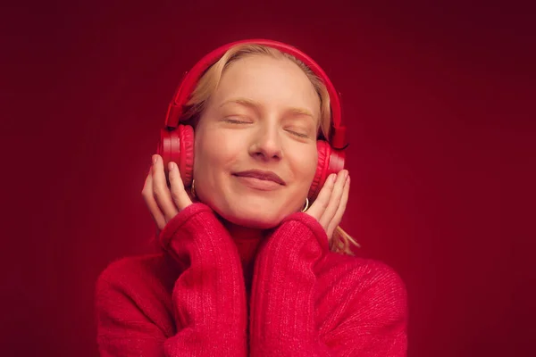 Μια Ευτυχισμένη Γυναίκα Που Ακούει Μουσική Ακουστικά Απομονωμένα Κόκκινο Φόντο — Φωτογραφία Αρχείου