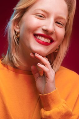 Portrait of a beautiful lady isolated on magenta background looking at the camera. Viva magenta, color of the year.