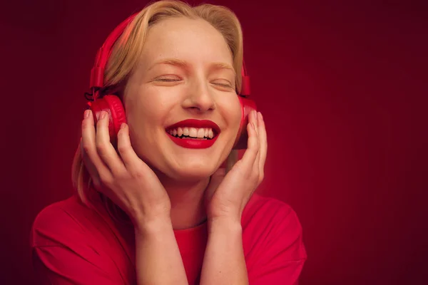 Μια Ευτυχισμένη Γυναίκα Χαλαρώνοντας Και Ακούγοντας Μουσική Απομονωμένη Κόκκινο Φόντο — Φωτογραφία Αρχείου