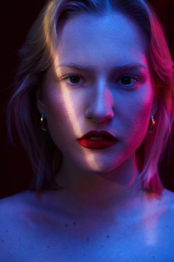 Beauty portrait of a serious blond woman with natural pure skin. Picture taken with photo gels.