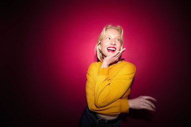 Portrait of a happy girl laughing and posing isolated on magenta background. Viva magenta, color of the year.