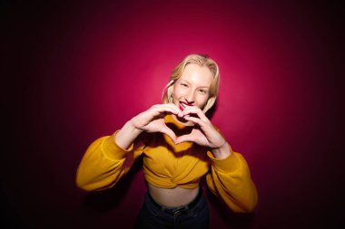Portrait of a happy girl laughing and posing isolated on magenta background. Viva magenta, color of the year.