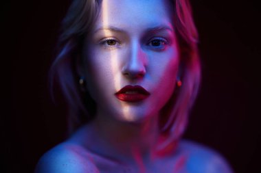 Kameraya bakan güzel sarışın bir kadının portresini yakından çek. Fotoğraf jeliyle çekilmiş. Neon titreşimli. Yılın rengi, viva moru..