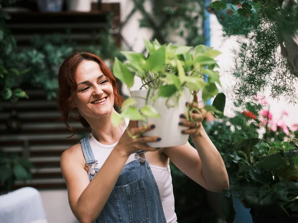 バルコニーに植物を植え 都市環境で緑の生活を育てている女性 — ストック写真
