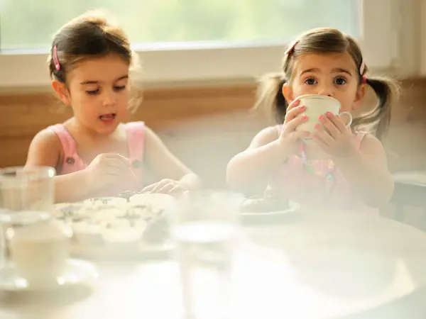 stock image Little girl baking muffins in a cozy kitchen with family on a sunny afternoon