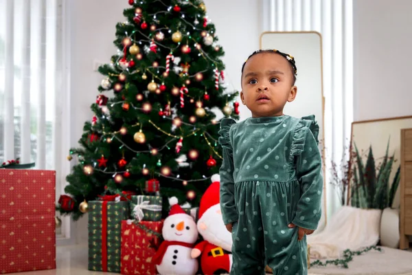 图片说明可爱的非洲裔美国小女孩站在客厅里 圣诞树下挂着许多礼品盒 孩子们在庆祝快乐的寒假 — 图库照片