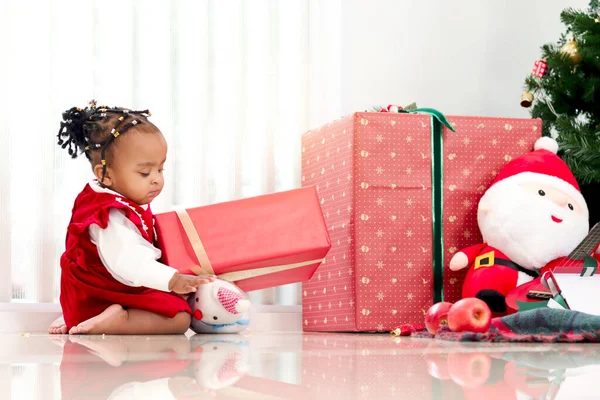 愛らしい笑顔の肖像アフリカ系アメリカ人の女の子の子供は リビングルームでクリスマスツリーの下に多くのギフトボックスプレゼントと座って 子供は幸せなクリスマス冬の休日を祝う — ストック写真