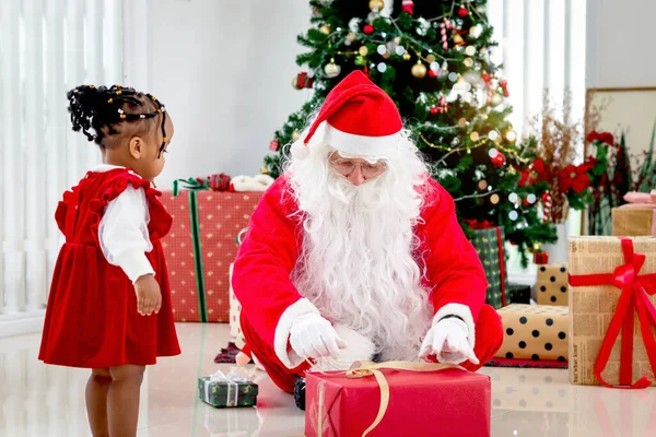 Счастливый Санта Клаус Обертывает Рождественскую Подарочную Коробку Перед Декоративной Елкой — стоковое фото