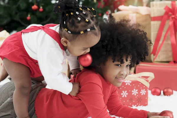 Два Симпатичных Афроамериканских Ребенка Играют Вместе Гостиной Подарочной Коробкой Елкой — стоковое фото