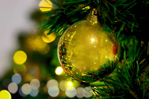 黄金黄色のクリスマスボールの装飾品ボケの光とクリスマスの緑の木 クリスマスの新年の装飾 美しいお祝いの木が飾られ 冬の休日の伝統的なお祝い — ストック写真