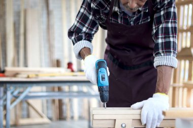 Asyalı usta marangoz marangoz marangozluk atölyesinde çalışıyor, marangozhanedeki çalışkan büyükbaba DIY hobisinin, marangozhanedeki çalışkan dedesinin keyfini çıkarıyor..