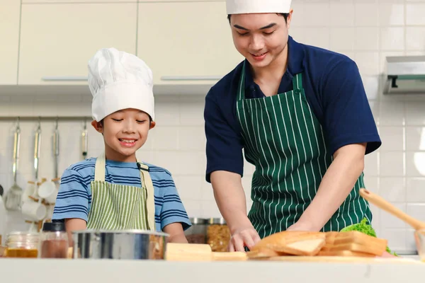 Feliz Sonriente Padre Asiático Hijo Niño Con Delantal Chef Sombrero —  Fotos de Stock