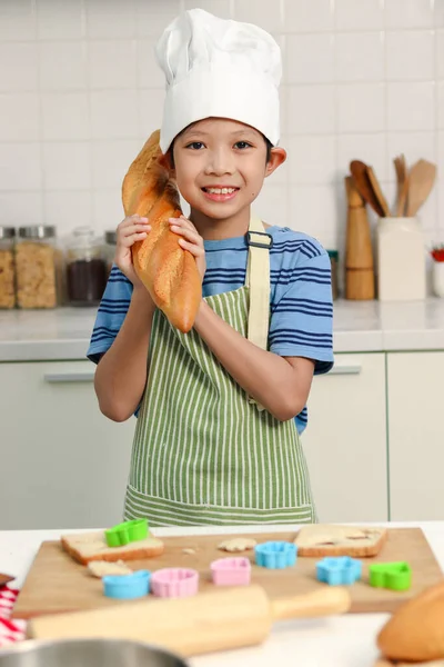Portret Szczęśliwego Uśmiechniętego Azjatyckiego Chłopca Fartuchem Kapeluszem Szefa Kuchni Trzymającego — Zdjęcie stockowe