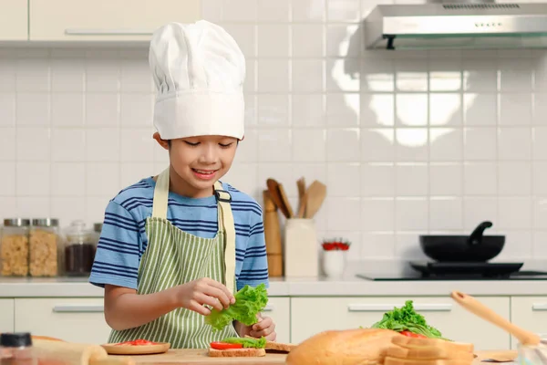 Feliz Niño Asiático Sonriente Con Delantal Sombrero Chef Colocación Verduras —  Fotos de Stock