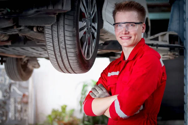 Retrato Sorrindo Bonito Mecânico Trabalho Uniforme Vermelho Com Veículo Levantado — Fotografia de Stock