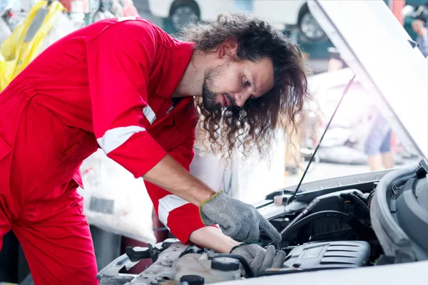 Lange Haare Schöner Mechaniker Mann Roter Uniform Arbeitet Mit Motorfahrzeug — Stockfoto