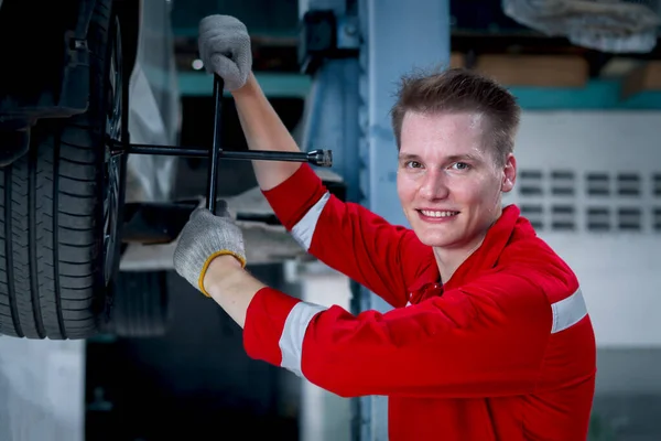 Homem Mecânico Bonito Sorridente Trabalho Uniforme Vermelho Com Veículo Levantado — Fotografia de Stock